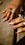 A close up of a person's hands with rings on them