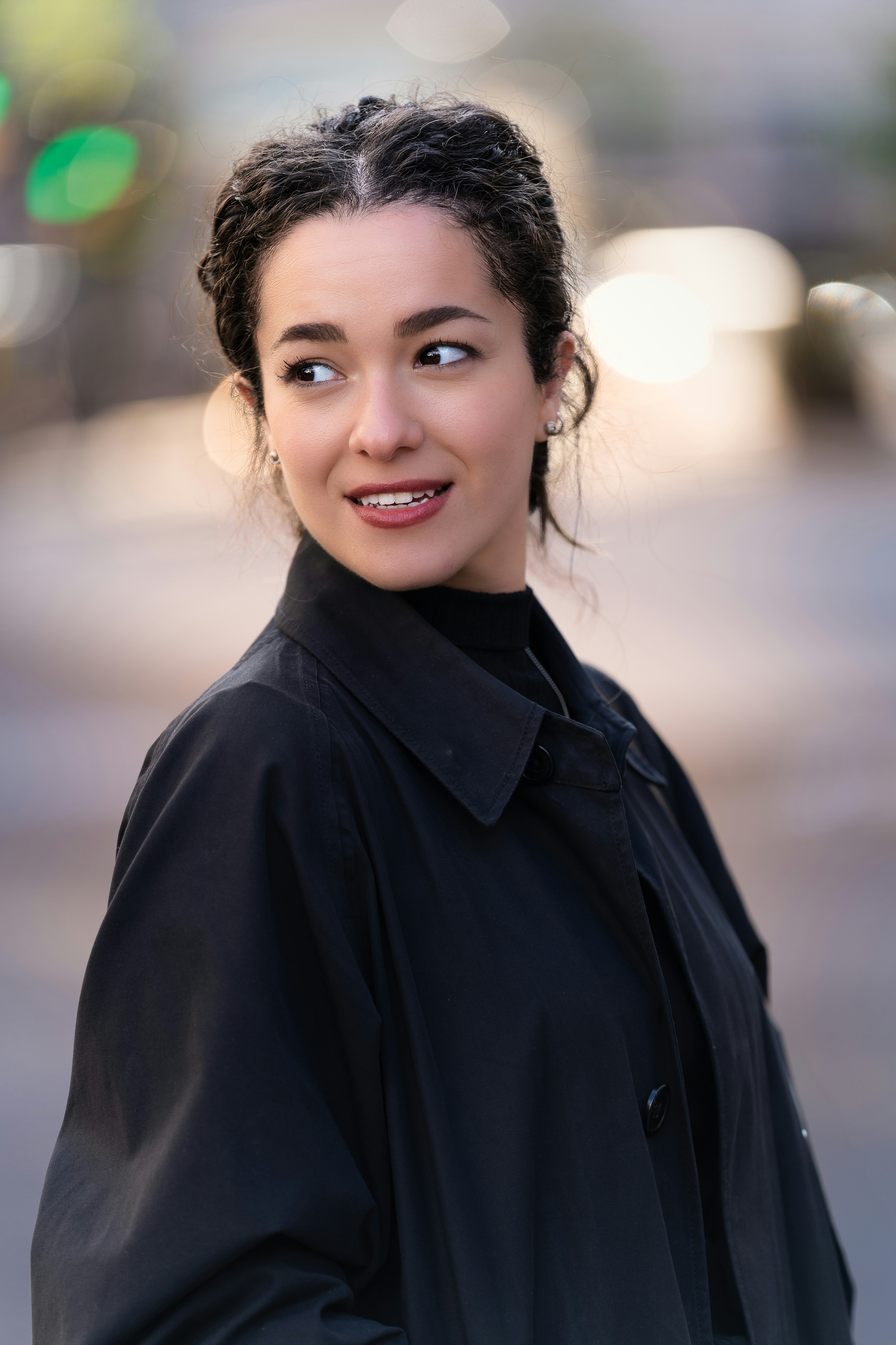 A woman standing on a street corner with a smile on her face