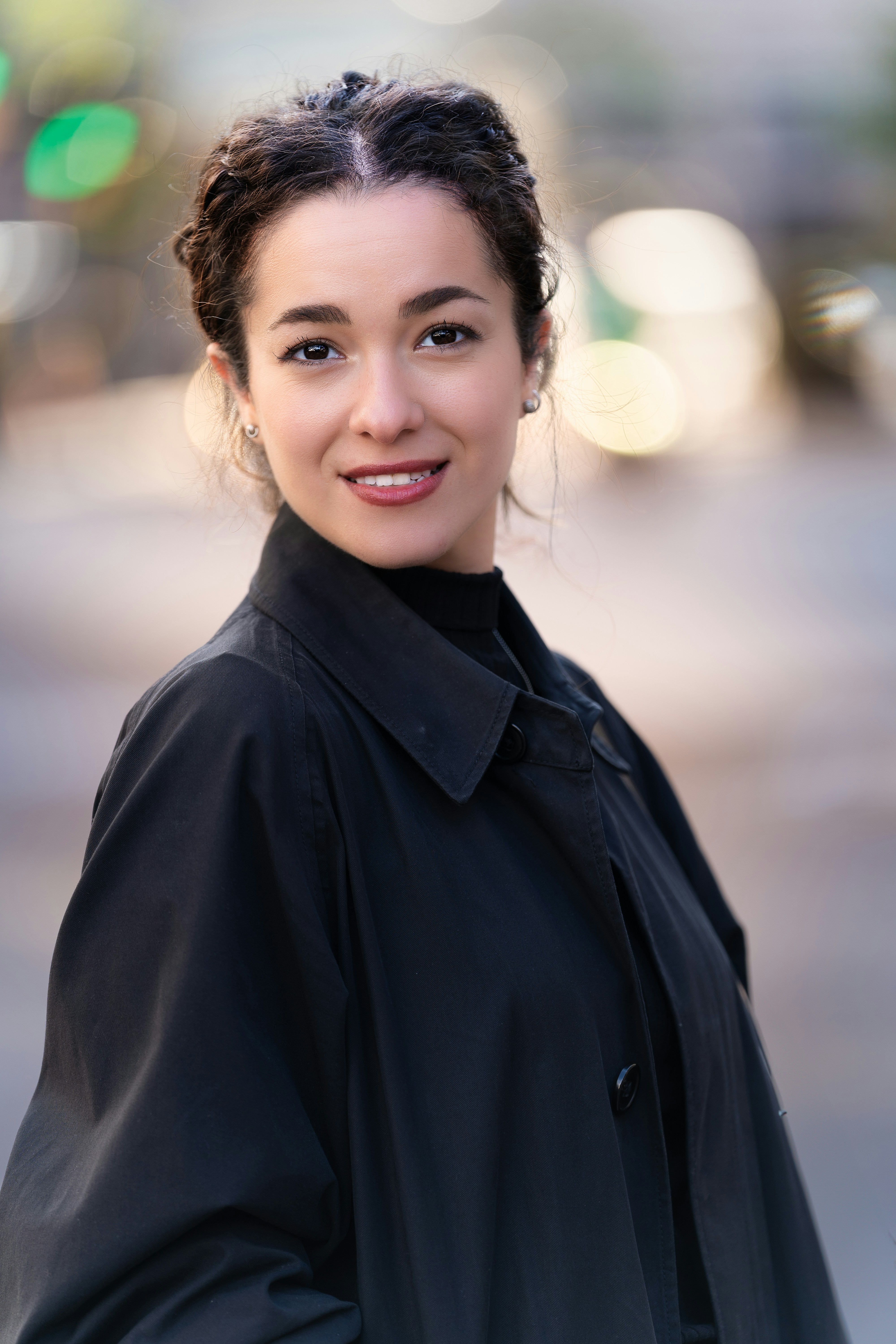 Una mujer de pie en una esquina con un abrigo negro