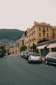 A street lined with parked cars next to tall buildings