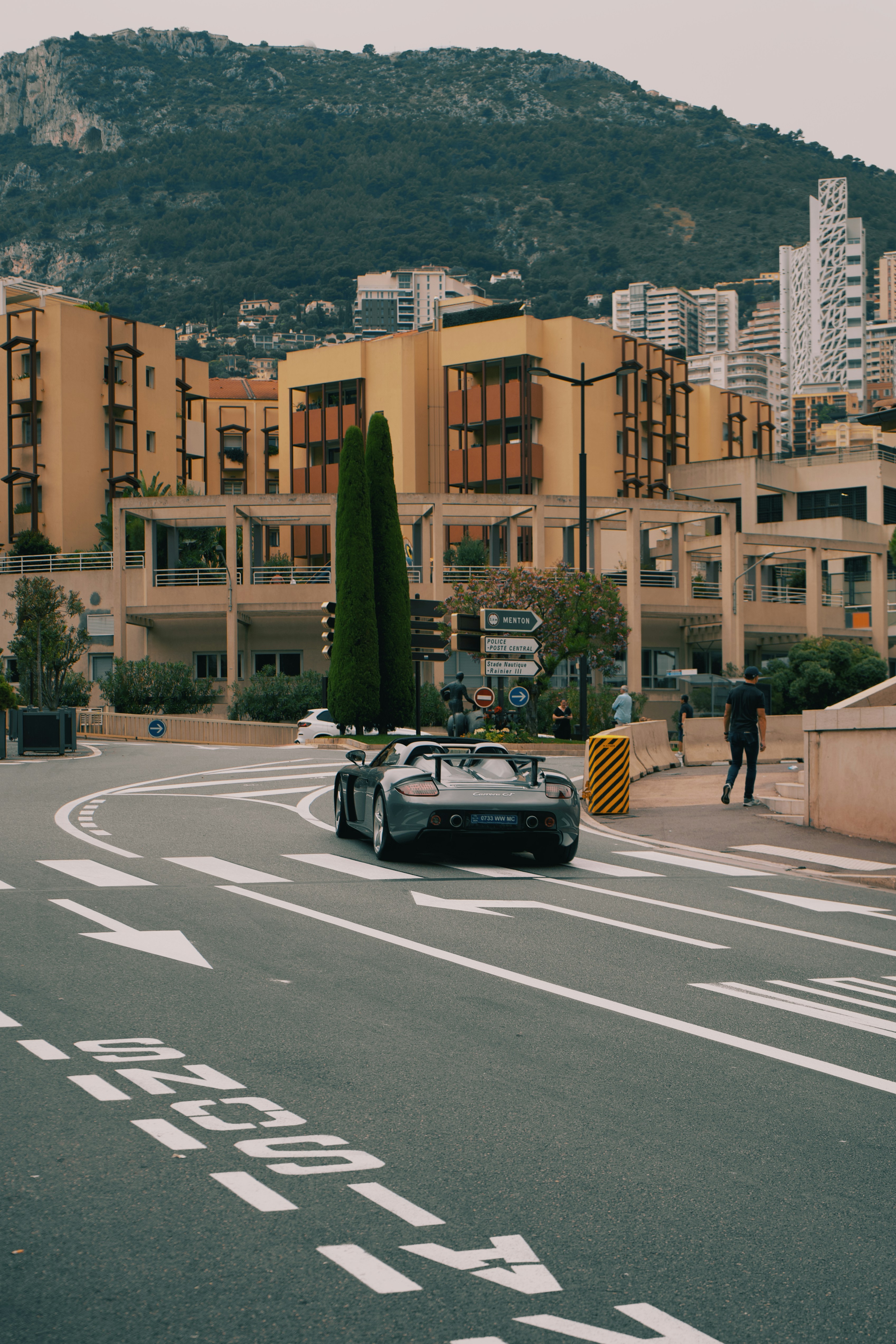 A car driving down a street next to tall buildings