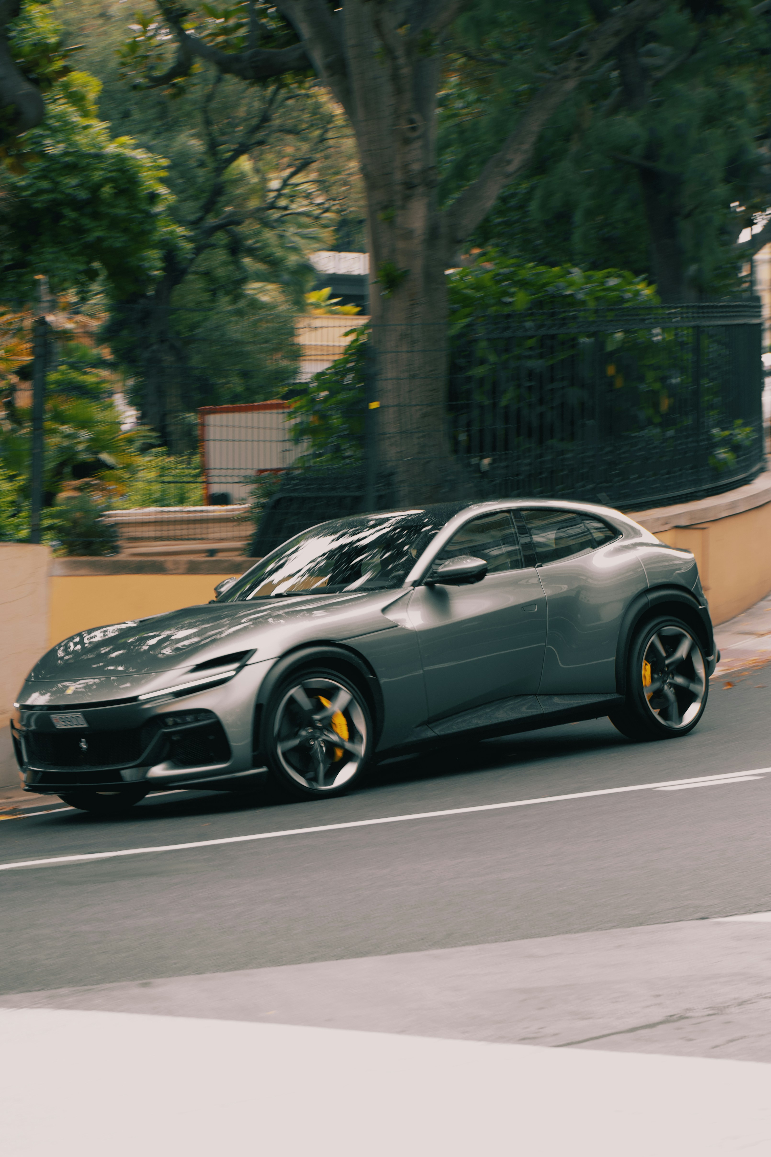 A grey sports car driving down a street