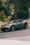 A grey ferrari purosangue driving down a street