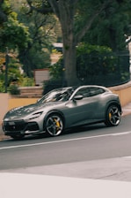 A grey ferrari purosangue driving down the road