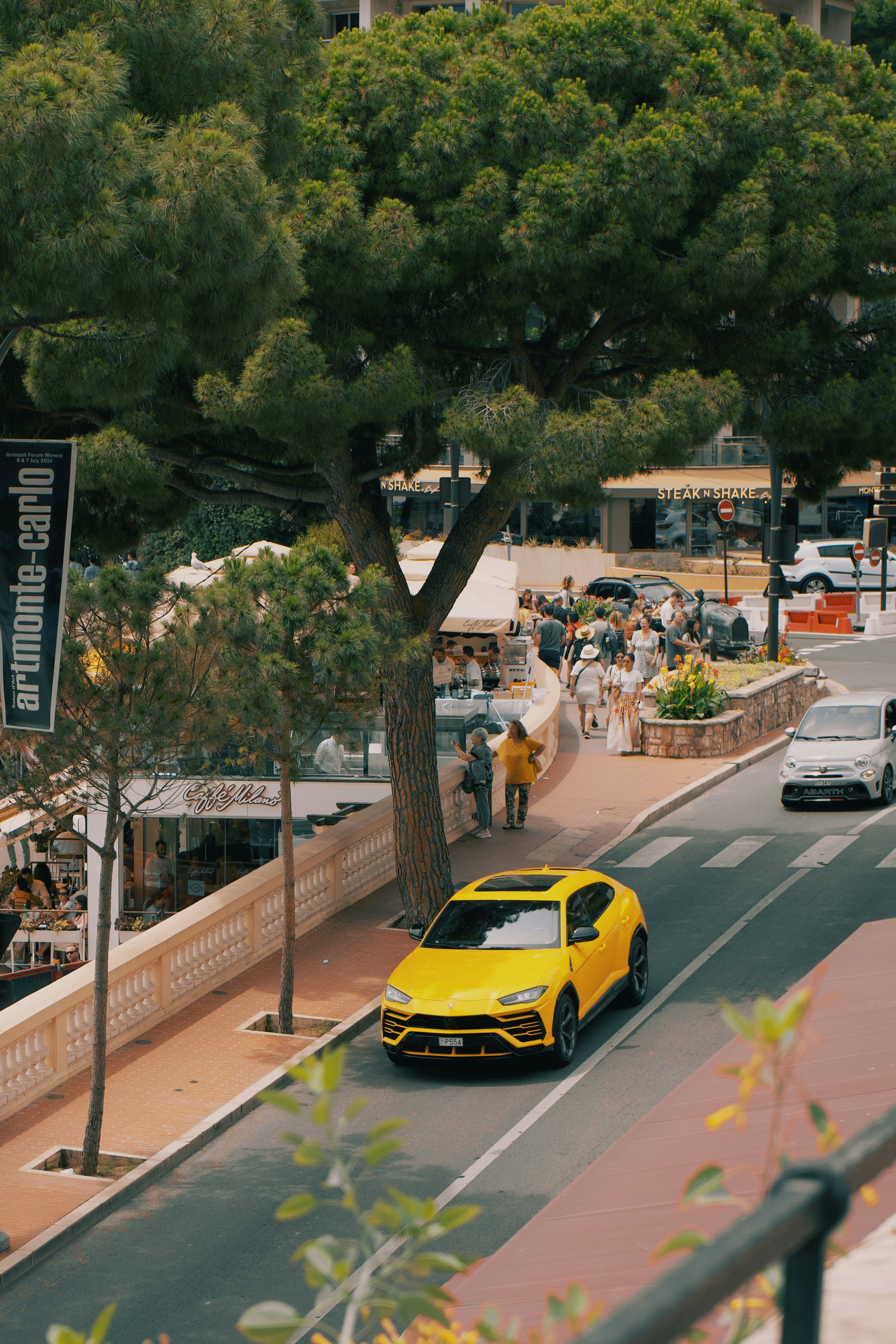 A yellow sports car driving down a street