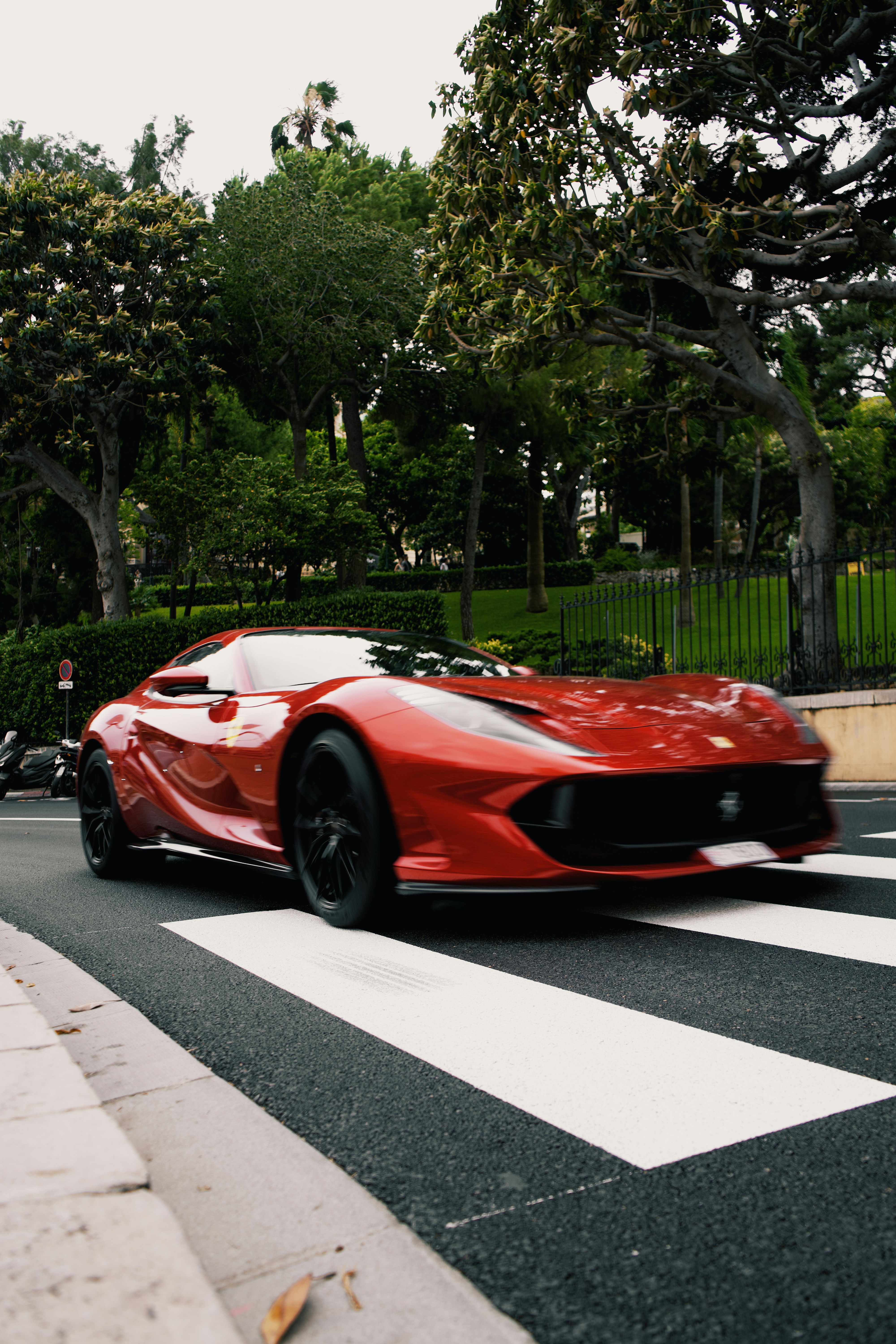 A red sports car driving down a street