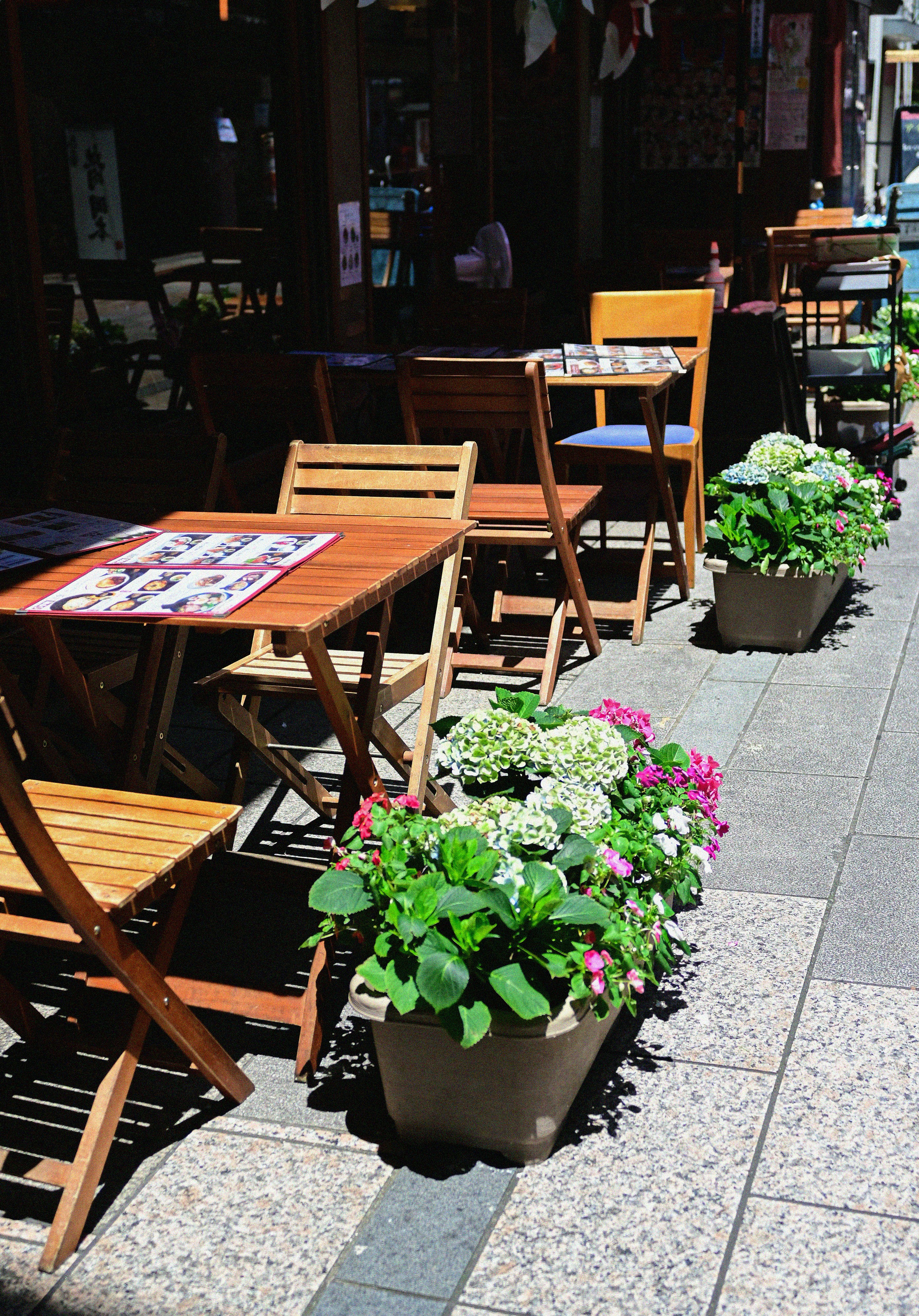 A row of wooden chairs sitting next to each other on a sidewalk