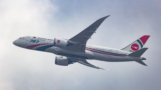A large jetliner flying through a cloudy blue sky