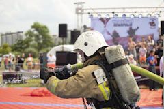 A fireman with a hose attached to his back