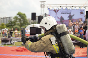 A fireman with a hose attached to his back