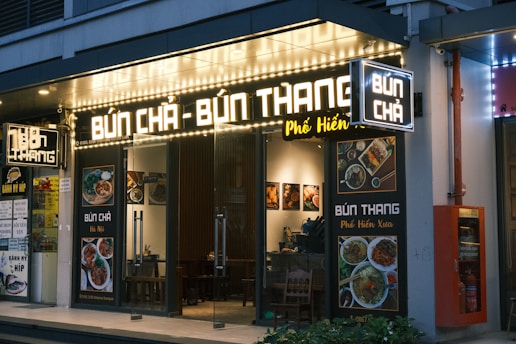 A restaurant called bun - bun thang is lit up at night