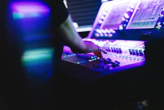 A man is using a sound board in a recording studio