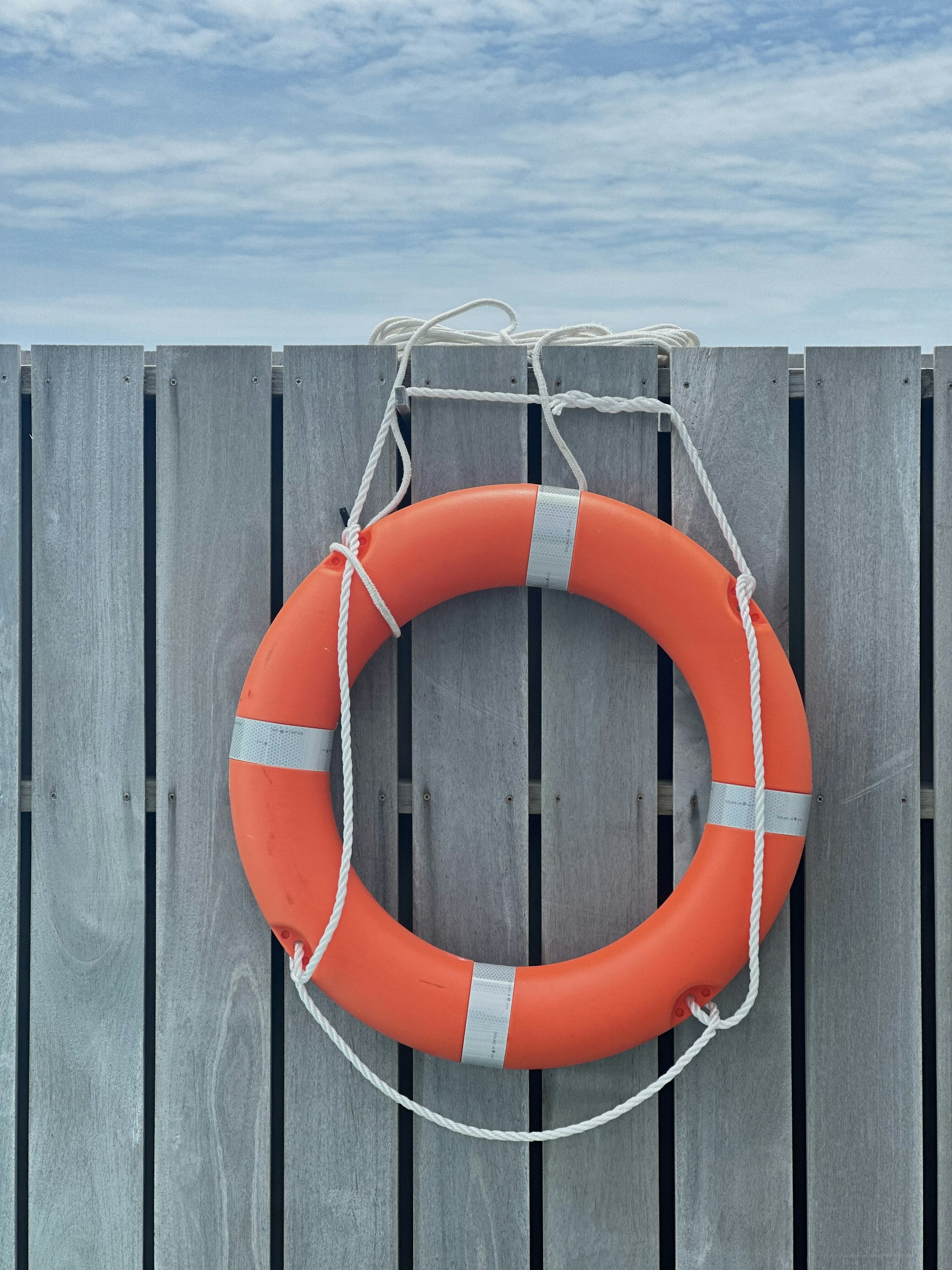 A life preserver hanging on a wooden fence