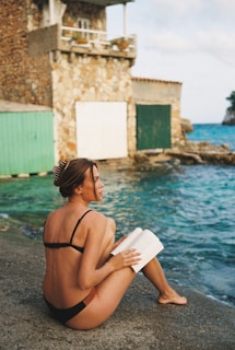 A woman sitting on the edge of a body of water