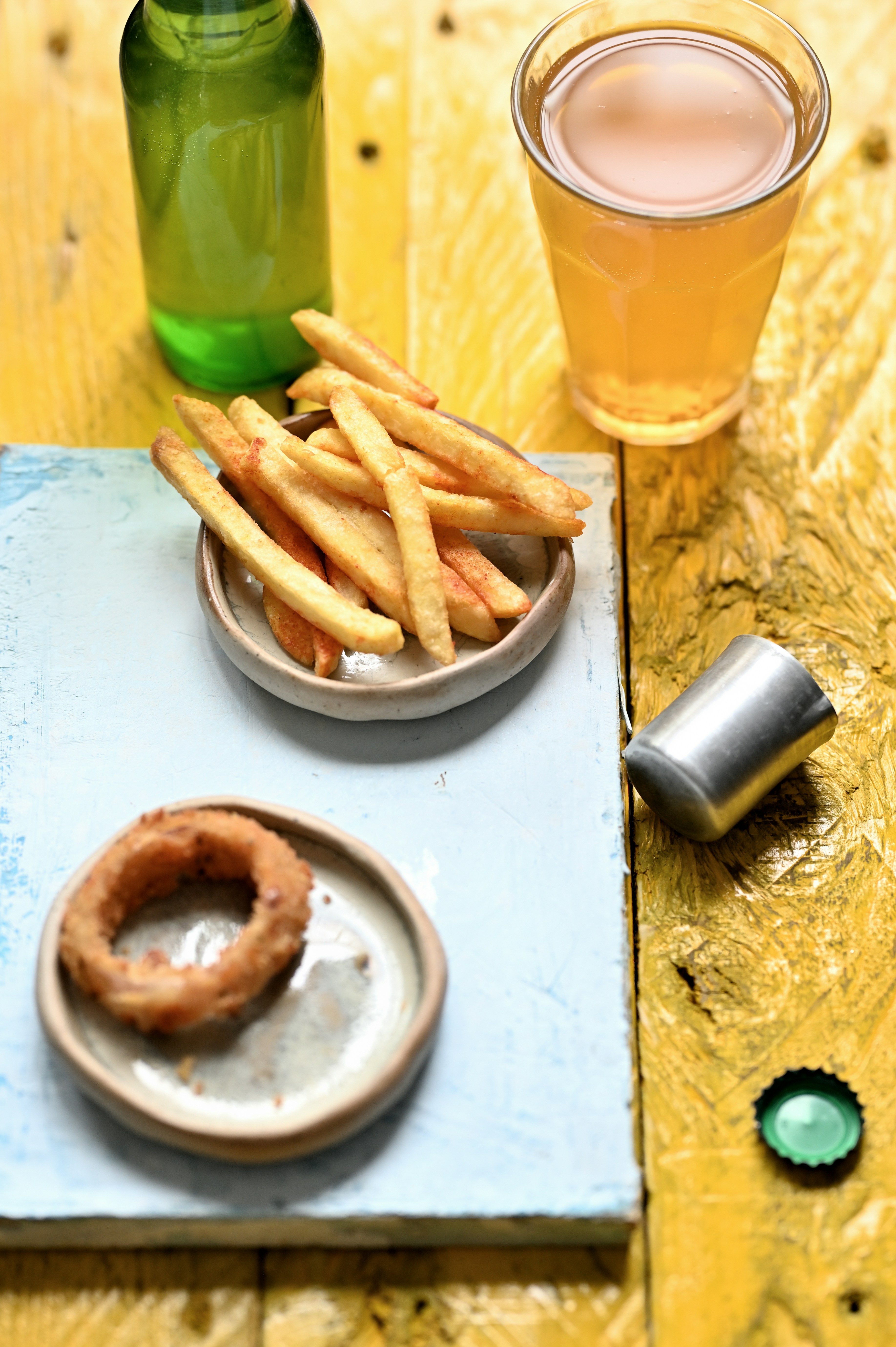 A wooden table topped with plates of food and drinks