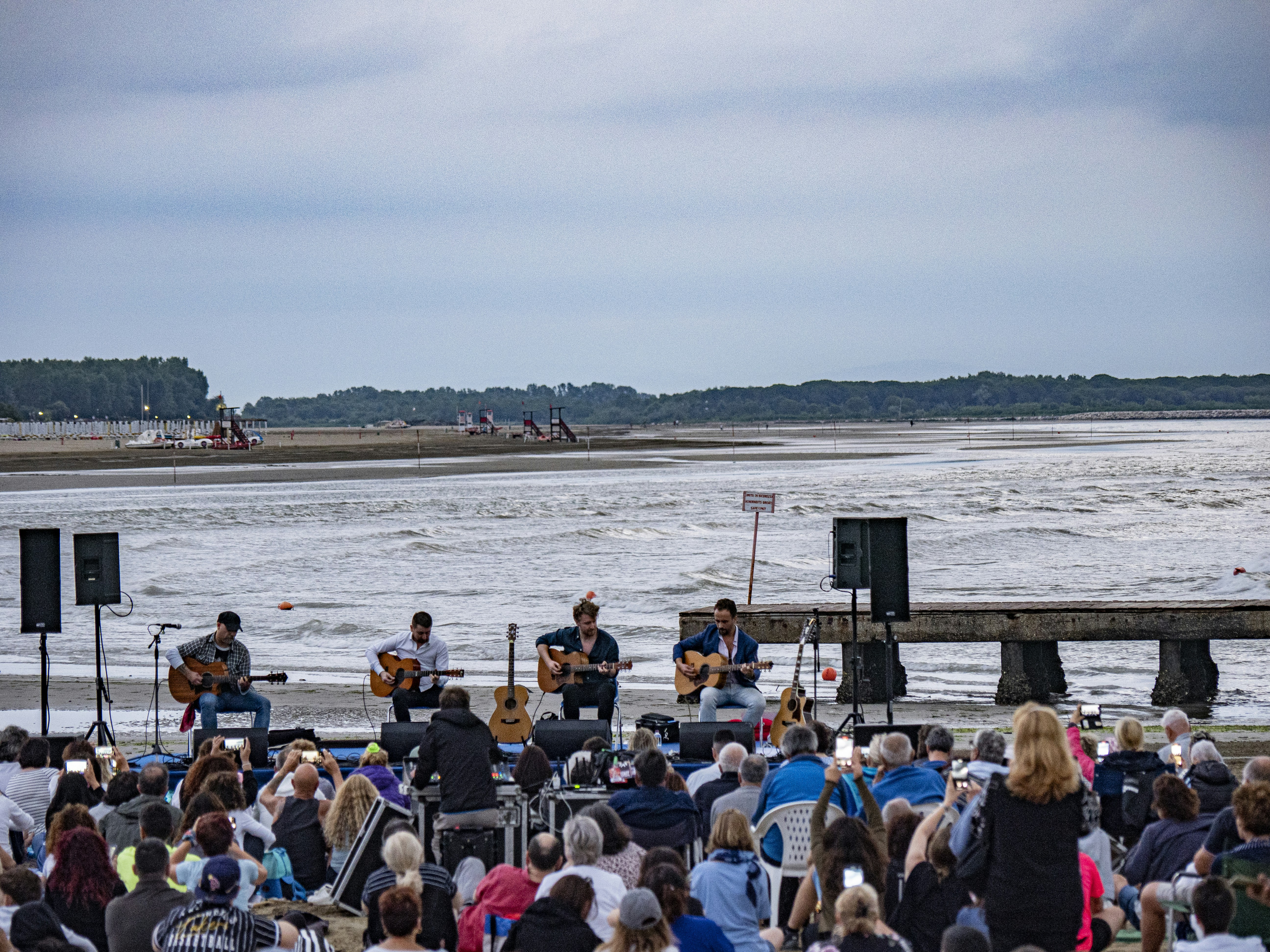 A group of people sitting in front of a body of water photo – Free ...