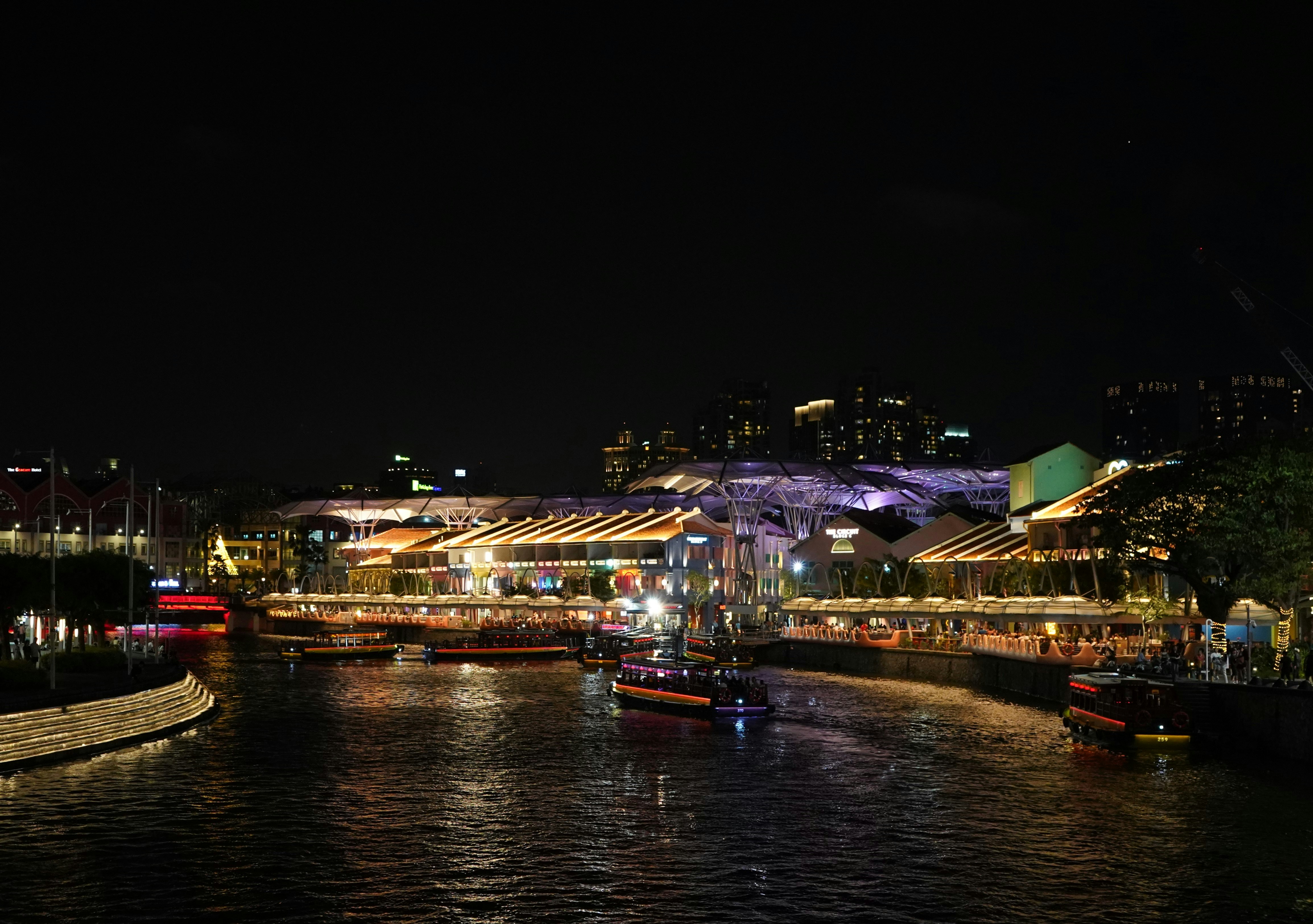 A river filled with lots of boats at night