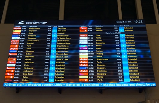 A large screen displaying a flight schedule at an airport