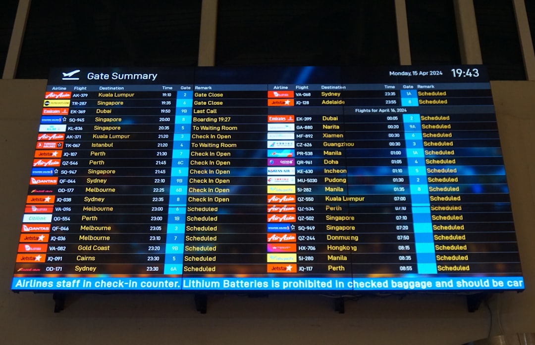 A large screen displaying a flight schedule at an airport,
