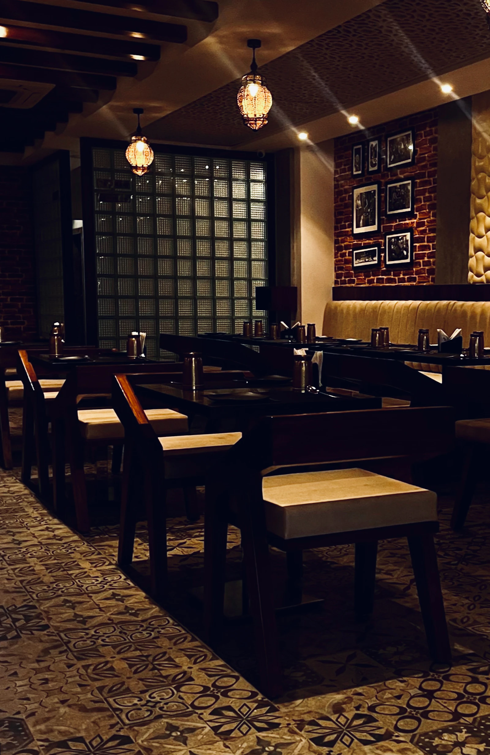 A dimly lit restaurant with wooden tables and chairs
