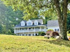 A large white house sitting on top of a lush green hillside