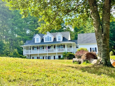 A large white house sitting on top of a lush green hillside