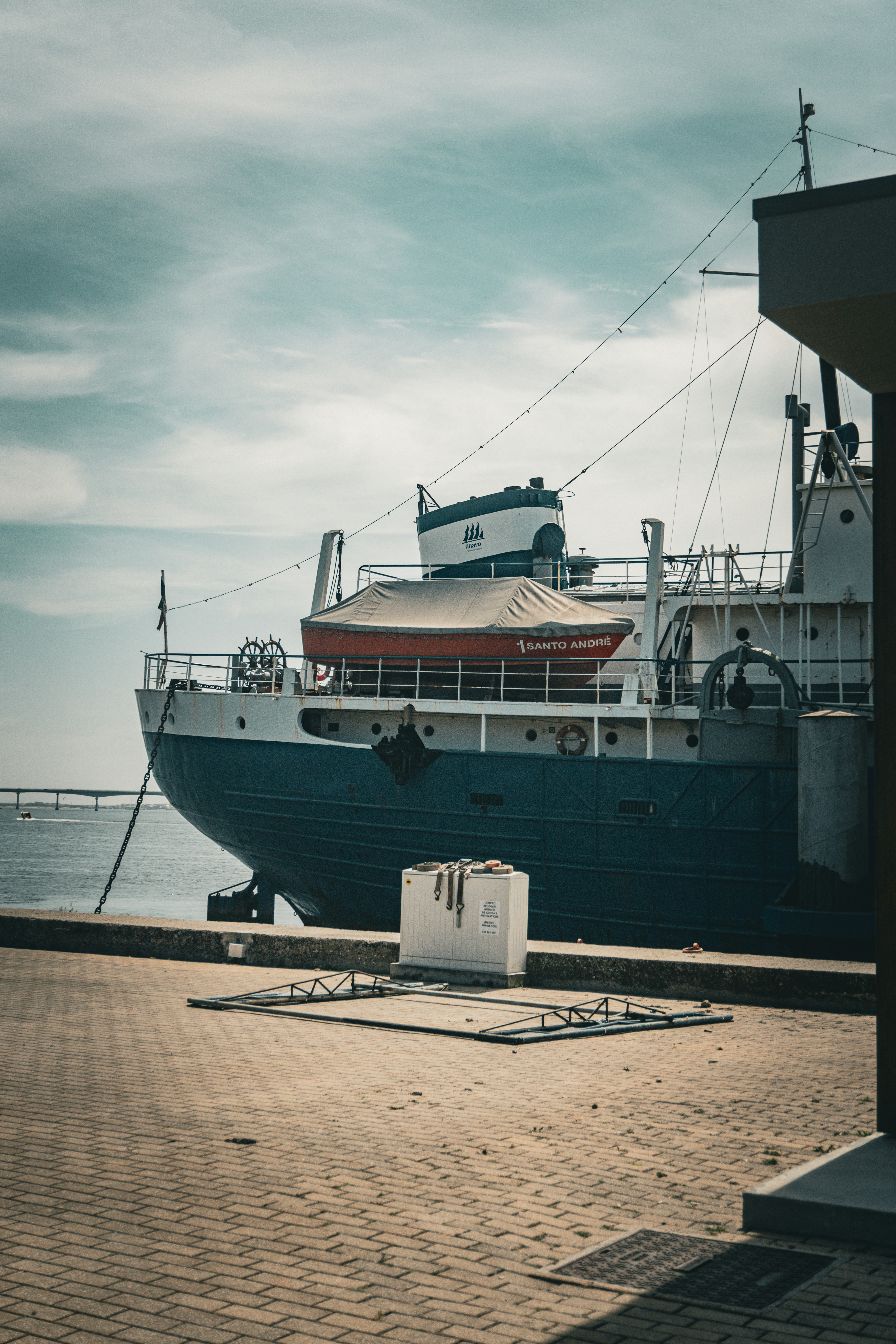 A large boat is docked at a pier
