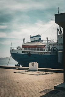 A large boat is docked at a pier