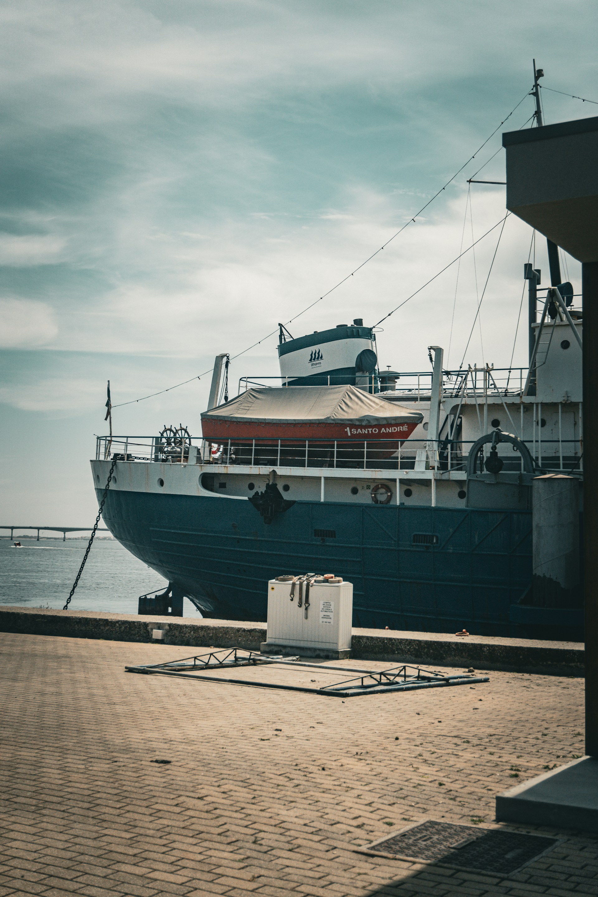 A large boat is docked at a pier