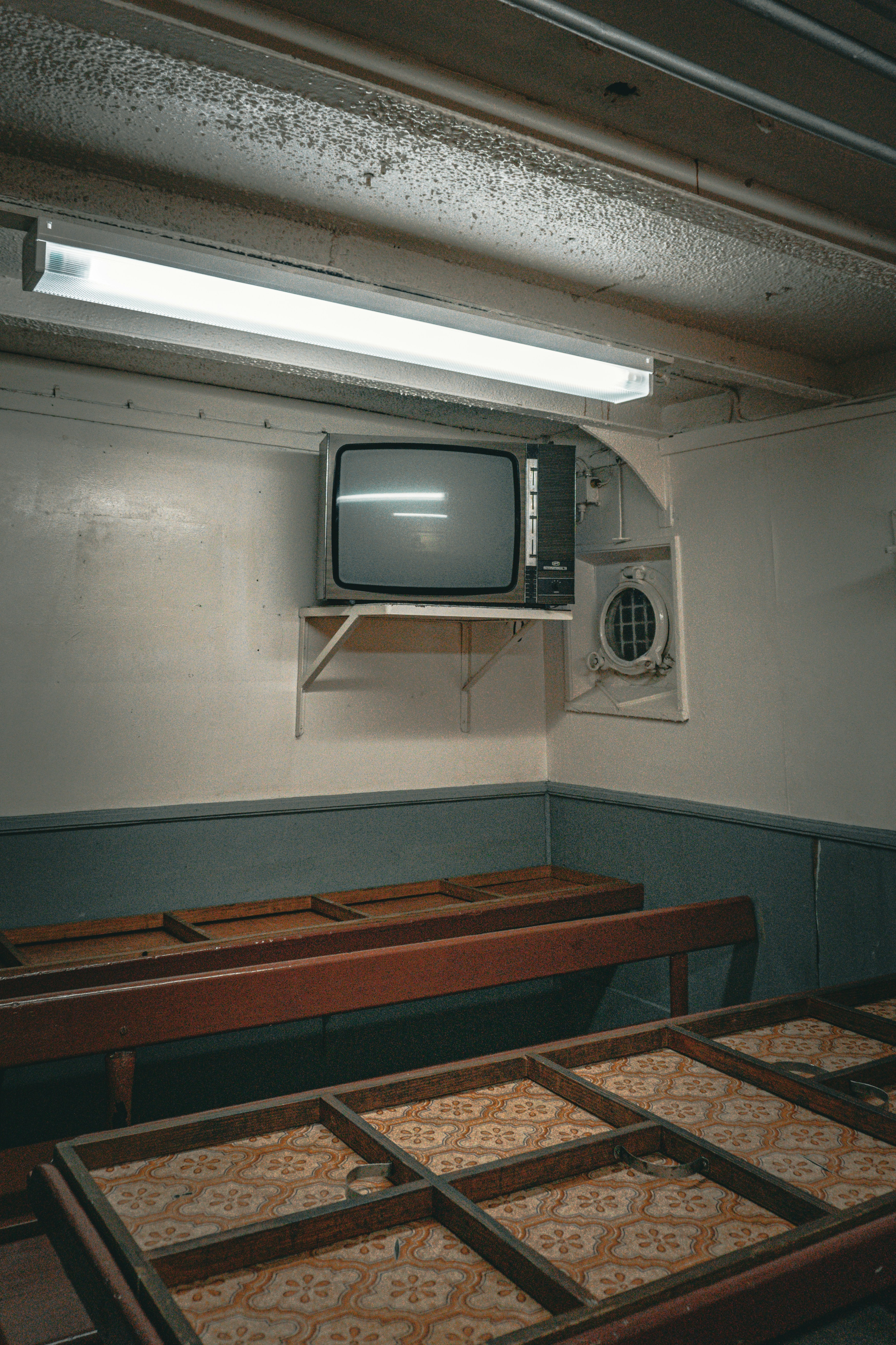 A room filled with wooden tables and a TV mounted on the wall