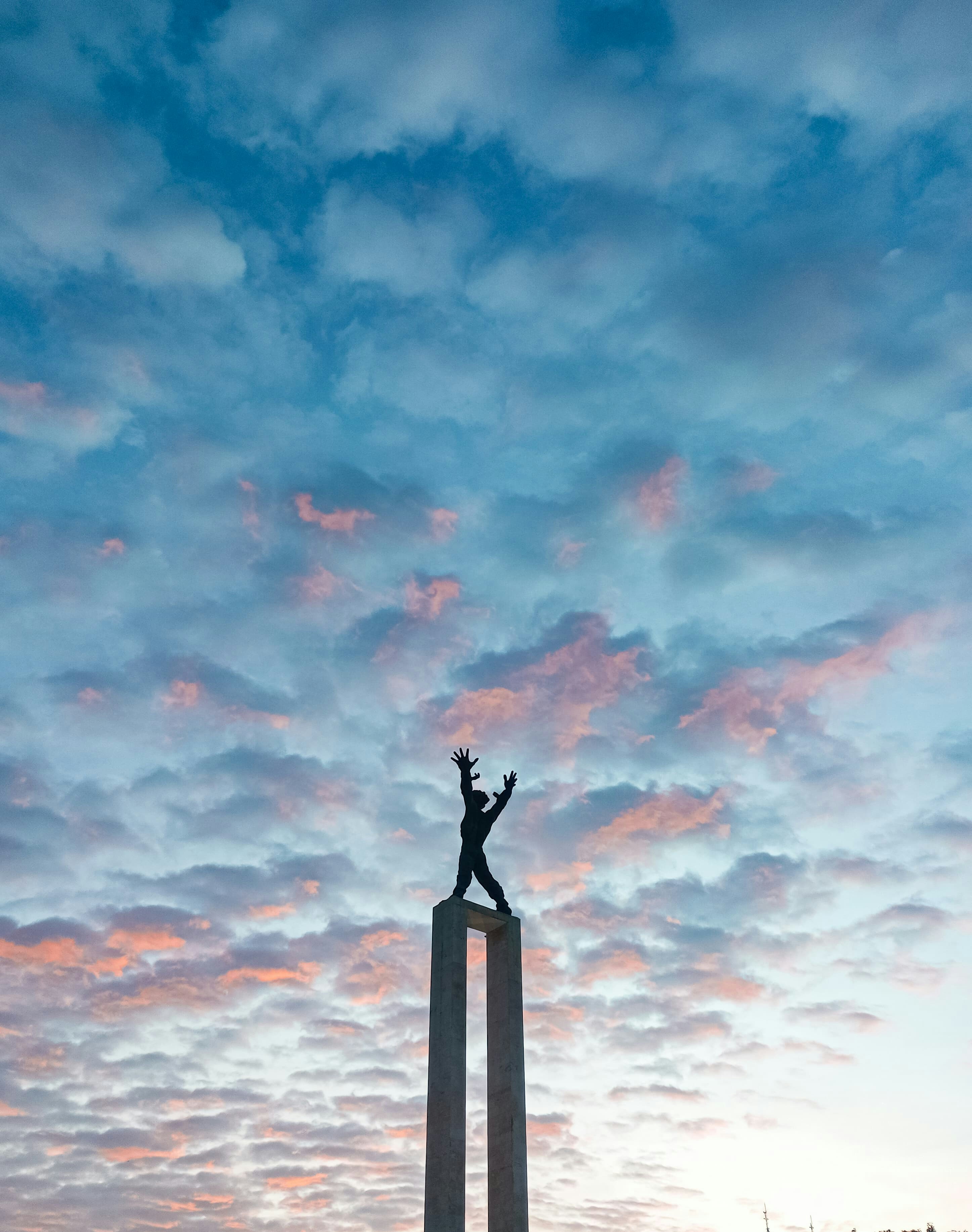 A person standing on top of a tall monument