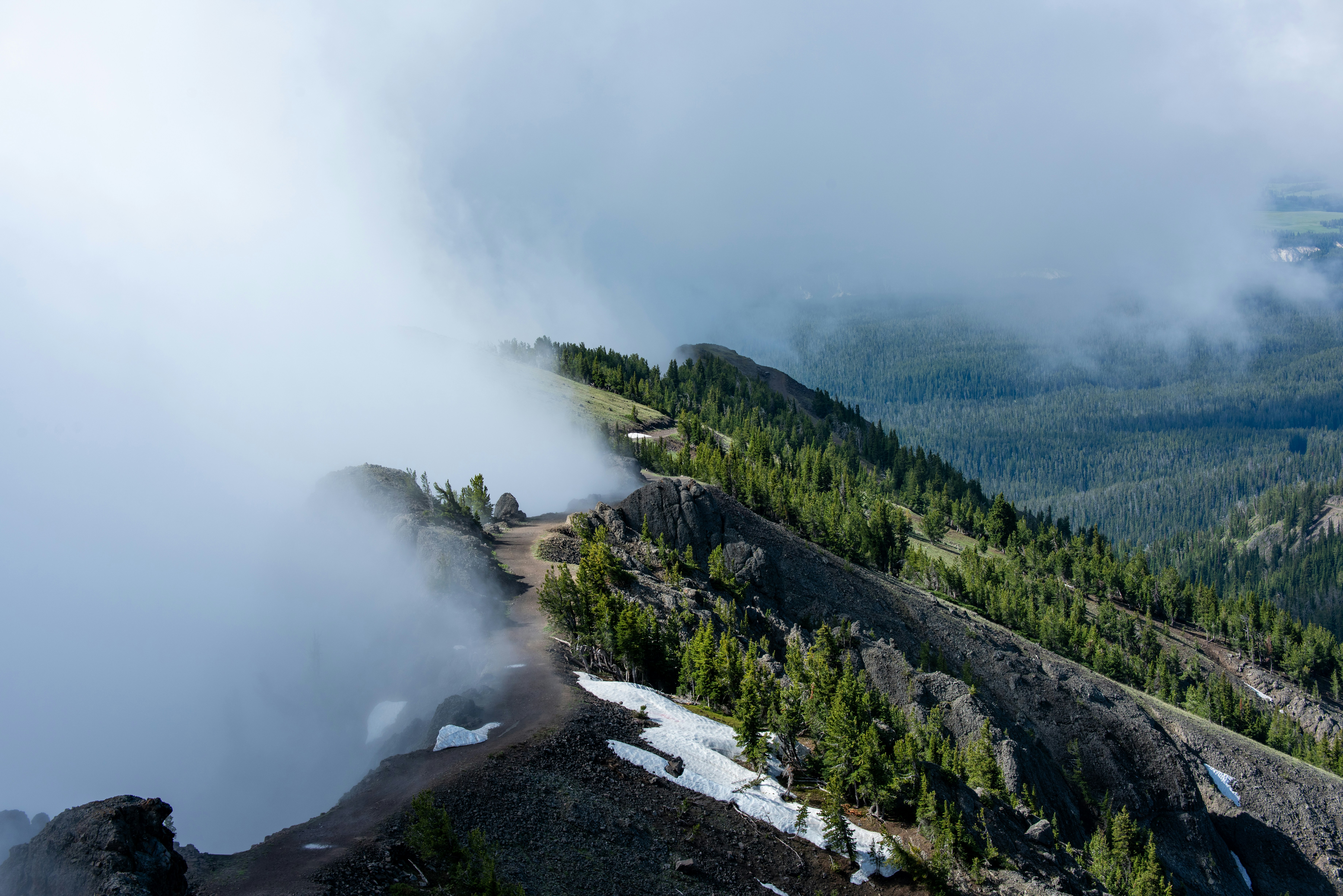 Une vue aérienne d’une montagne avec un nuage dans le ciel
