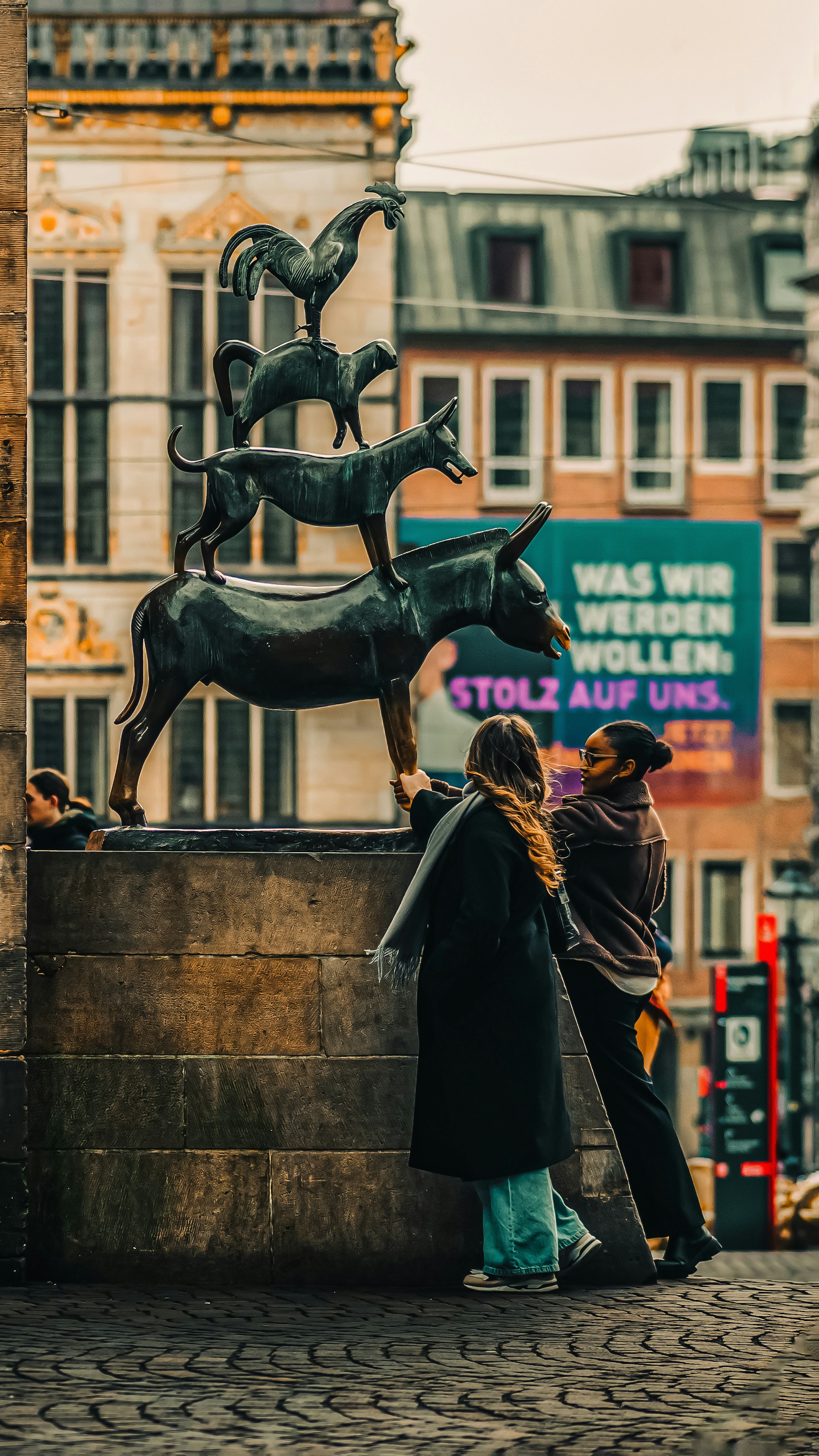 A couple of people standing next to a statue