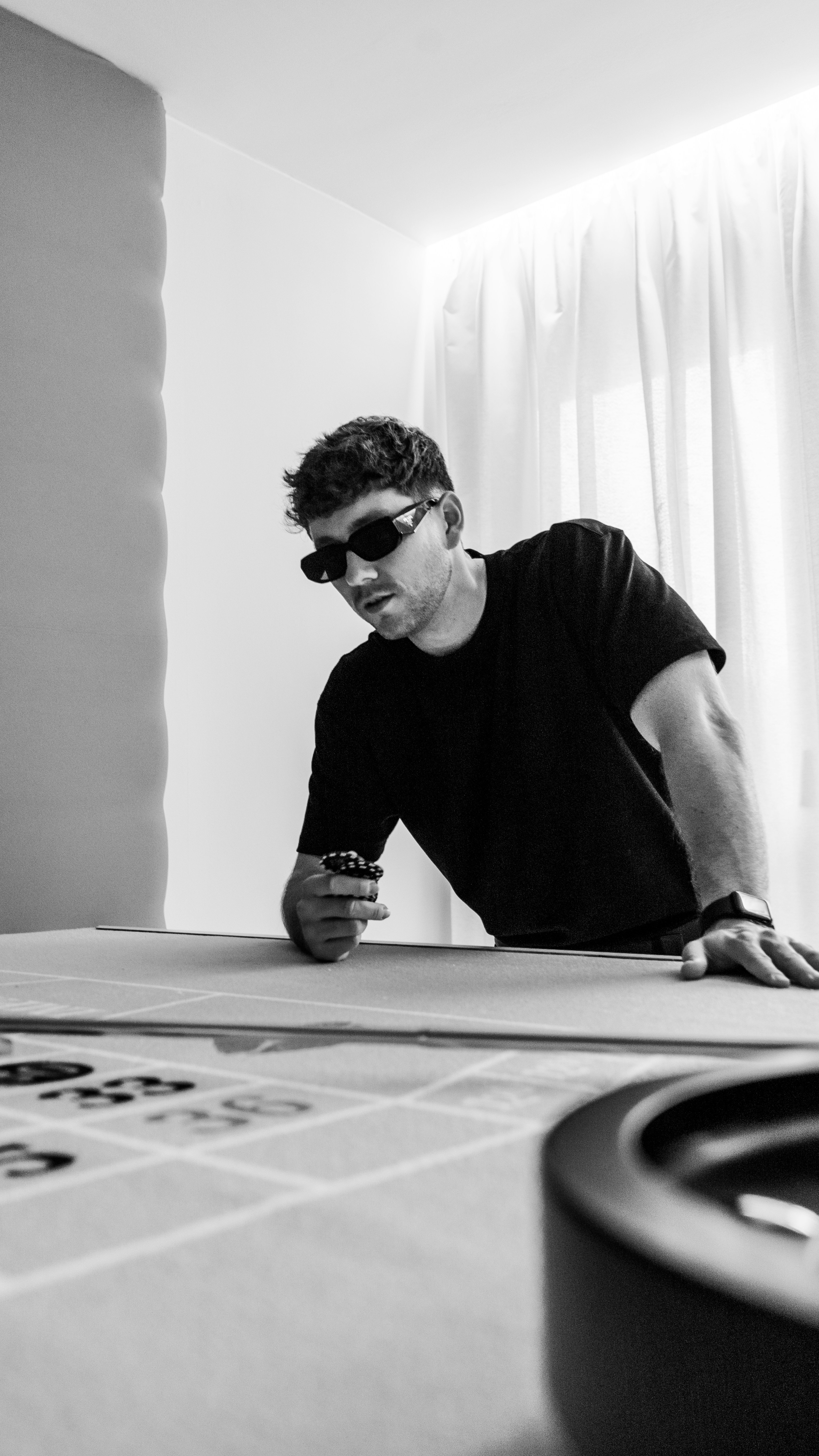 A man sitting at a table looking at a cell phone