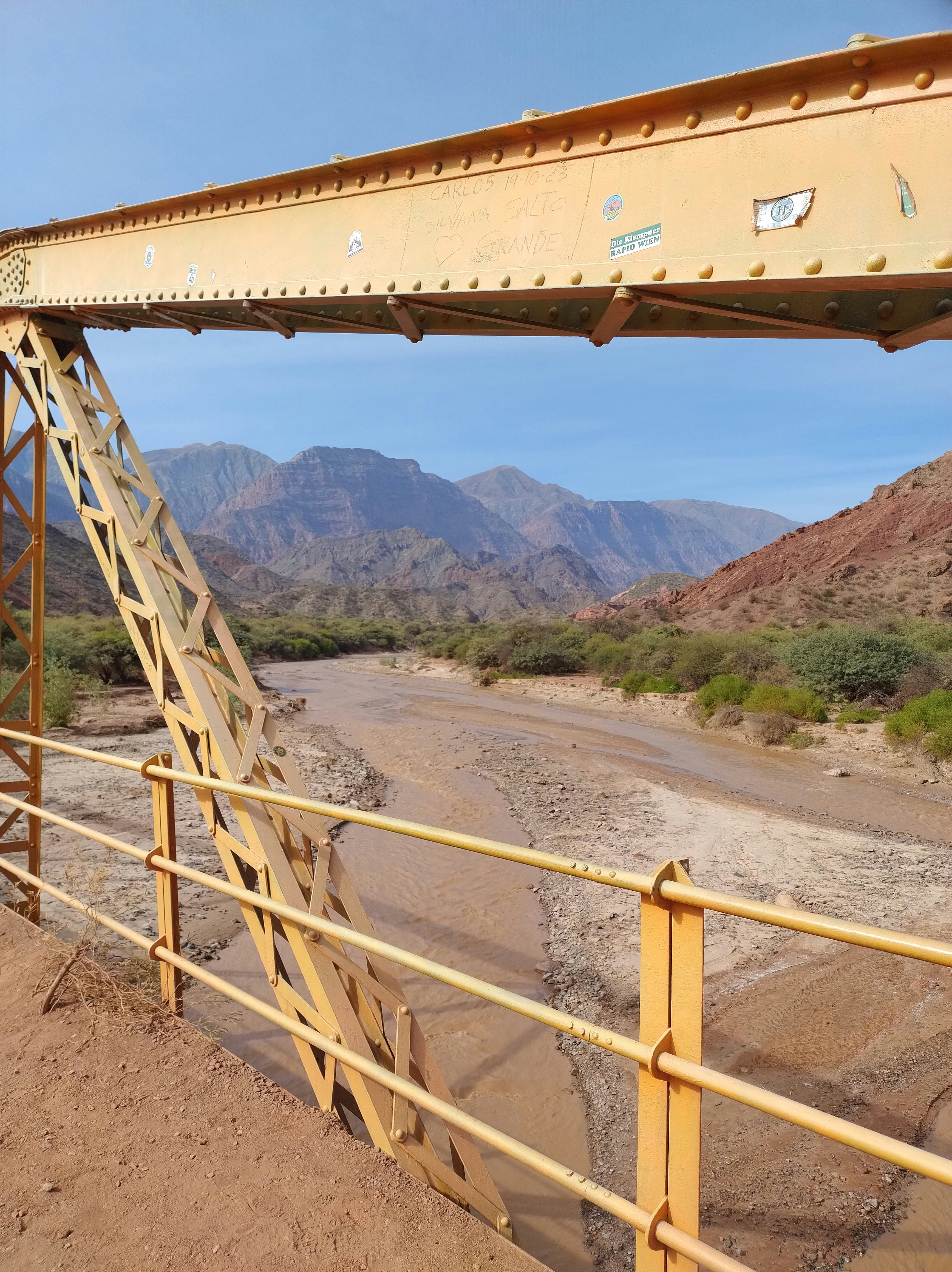 A bridge over a river with mountains in the background