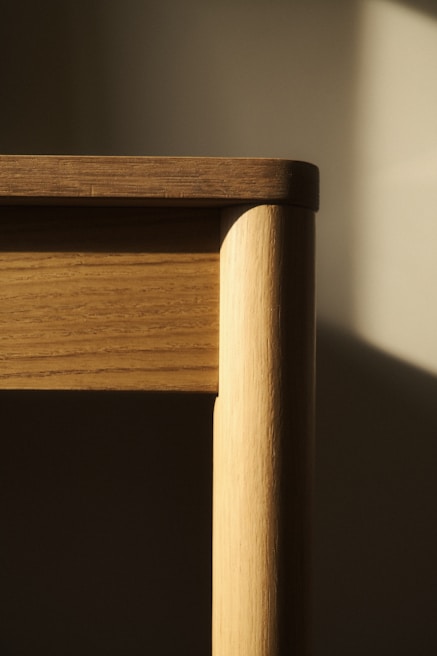 A close up of a wooden chair with a window in the background