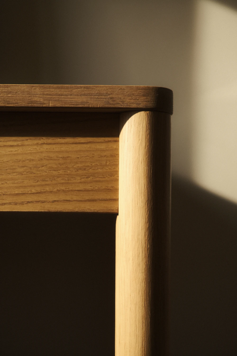 Silla de madera junto a una ventana con luz de tarde