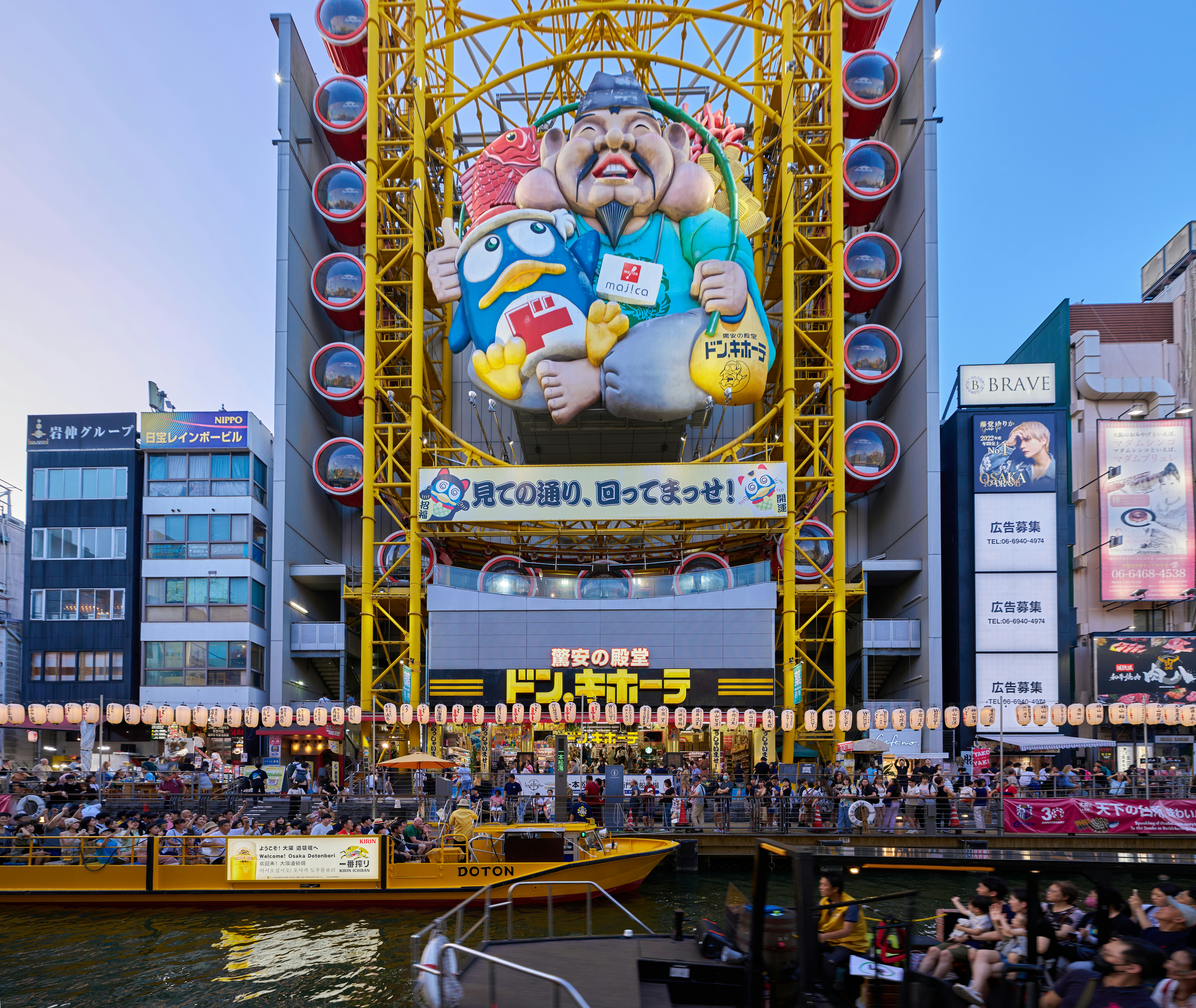 A crowd of people standing around a large ferris wheel
