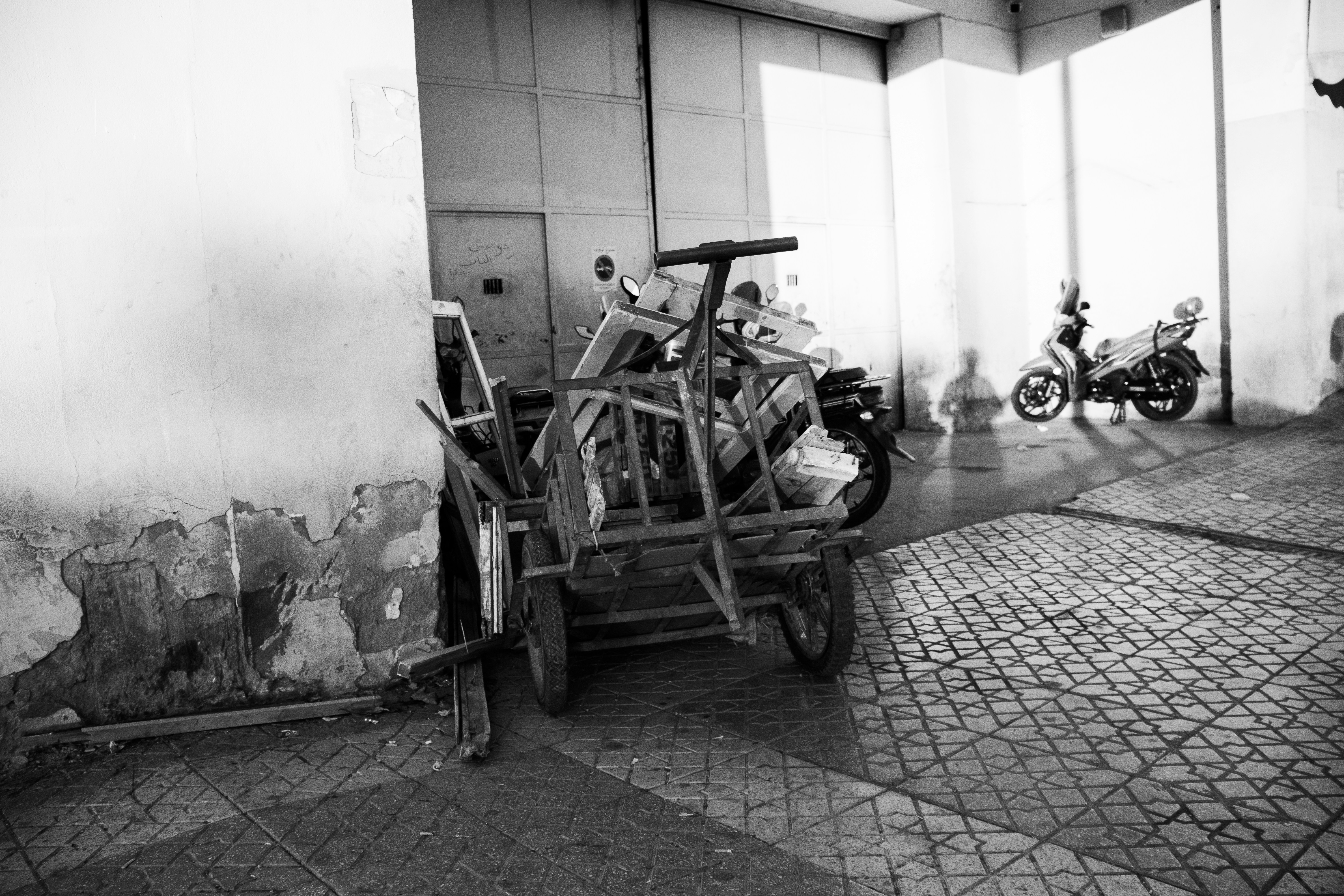 A black and white photo of a motorcycle and a cart