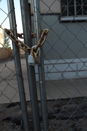 A chain link fence with a building in the background