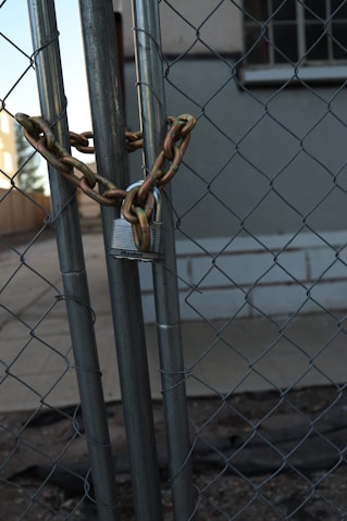 A chain link fence with a building in the background