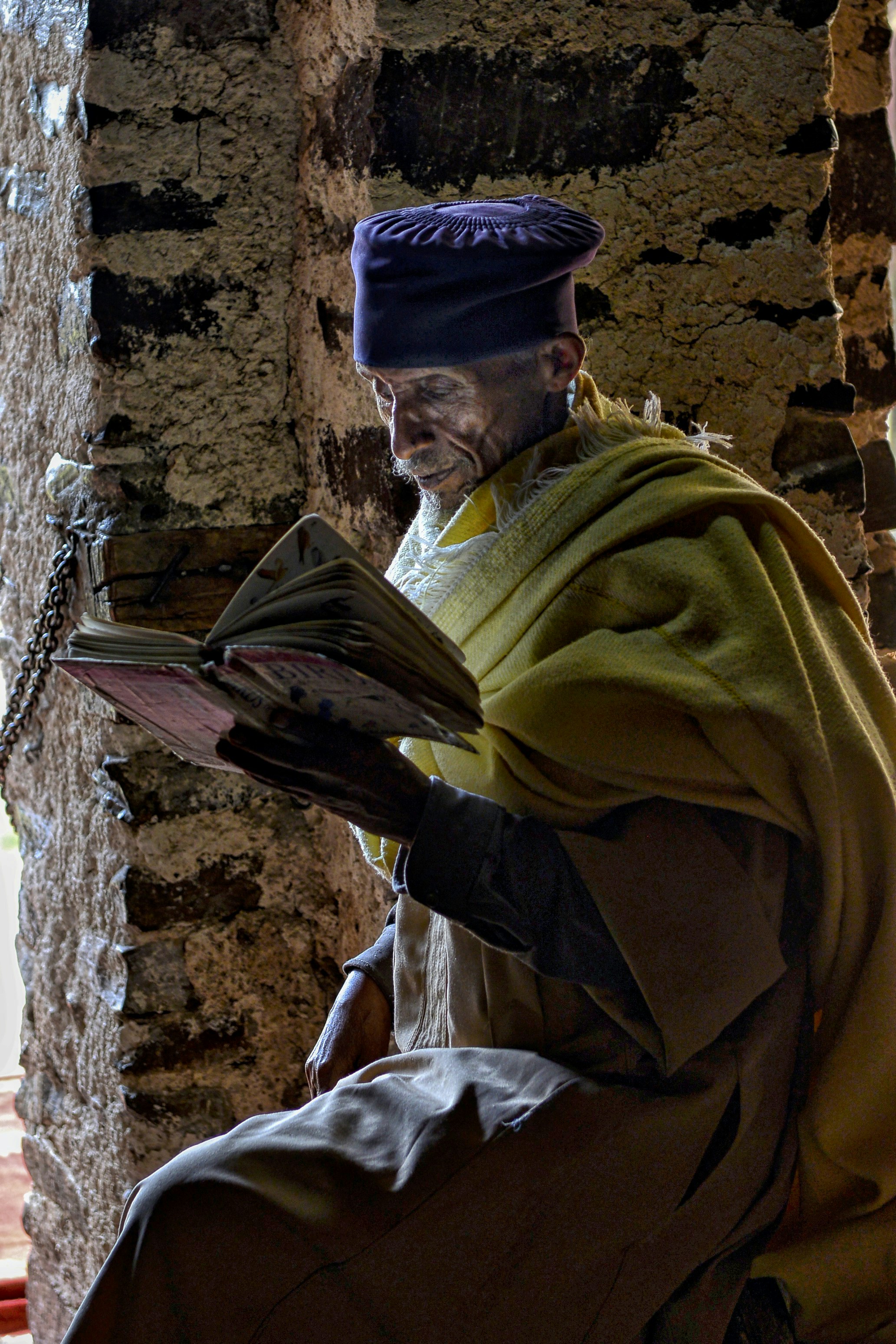A man sitting on a bench reading a book