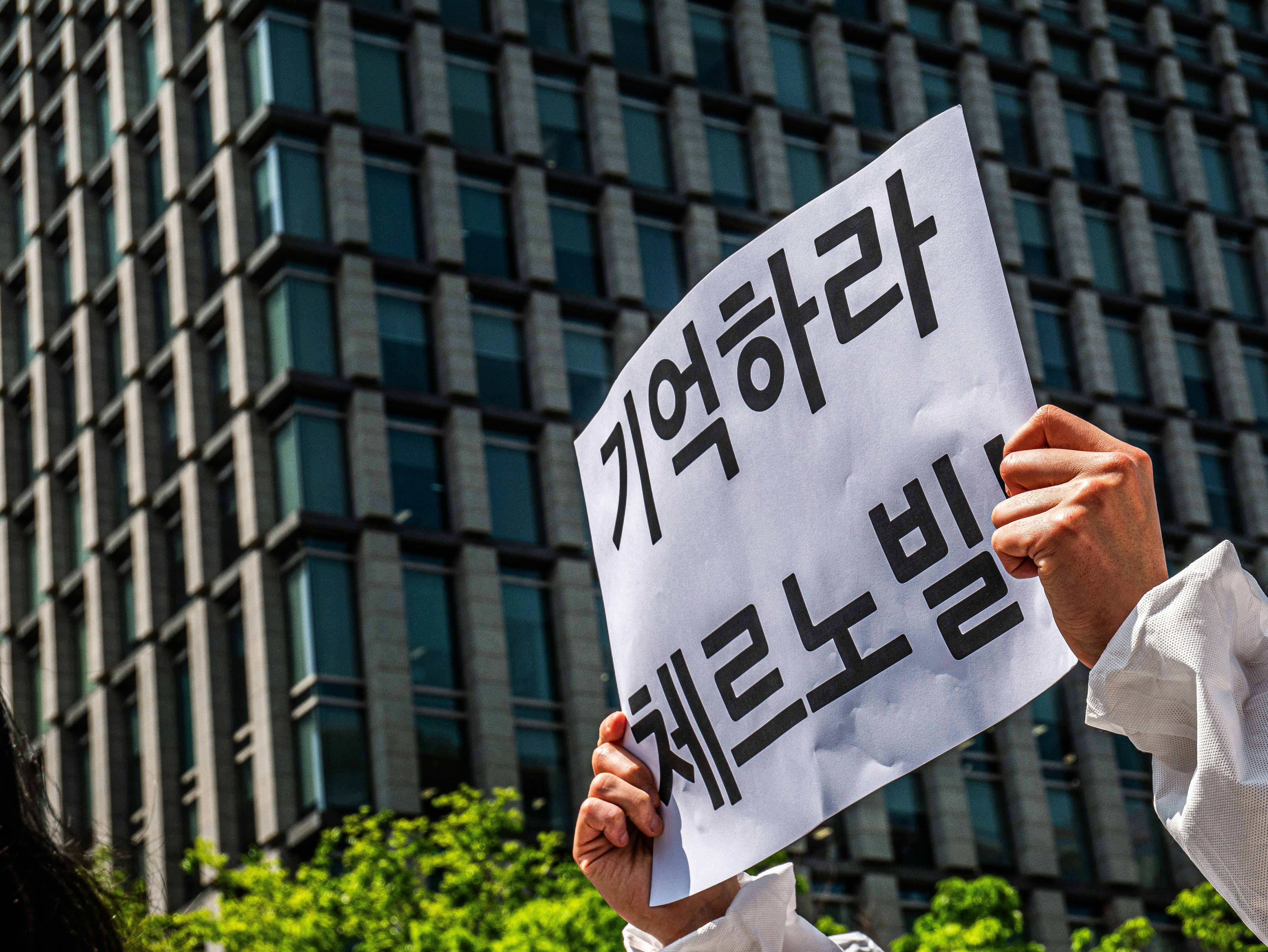 A woman holding a sign in front of a building