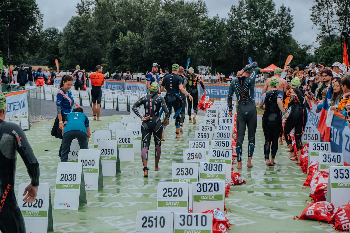 Triathlètes en combinaison dans l’eau, évoquant la natation et le triathlon