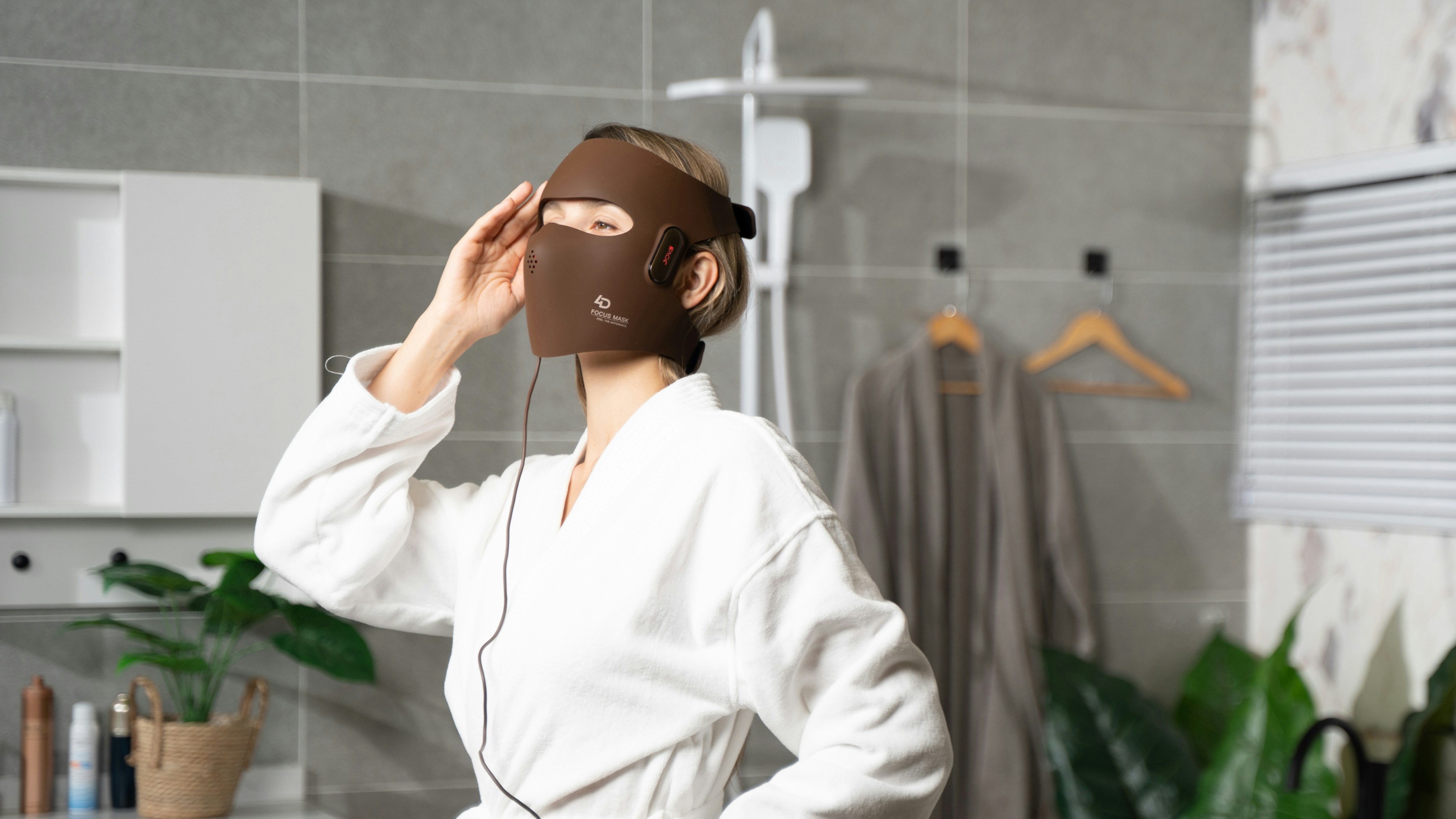 A woman standing in a bathroom wearing a mask