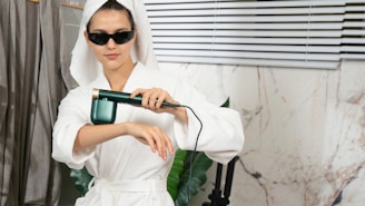 A woman in a bathrobe holding a hair dryer