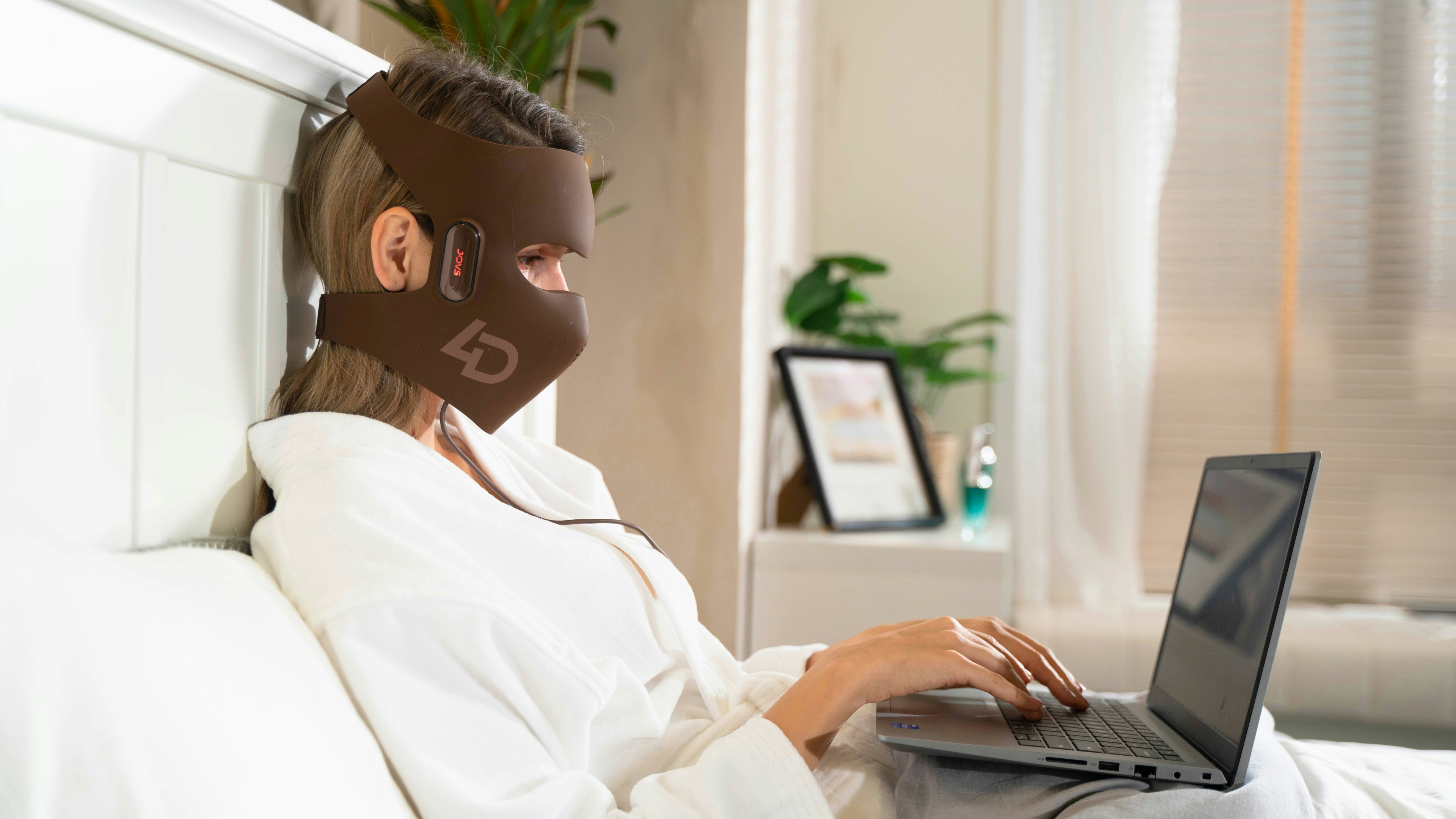 A person wearing a mask using a laptop