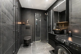 A washer and dryer in a bathroom with a skylight