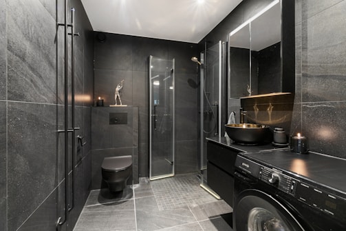 A washer and dryer in a bathroom with a skylight