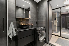 A washer and dryer in a bathroom with a skylight